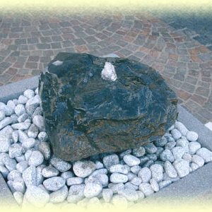 Basalt-Quellstein       auf hellgrauem Zierkies in Basalt-Becken 